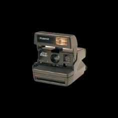 an old polaroid camera on a black background