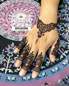 a woman's hand with henna tattoos on it