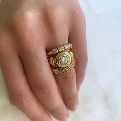 a woman's hand with a gold ring and diamond set on top of it