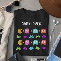 a t - shirt that says game over on it next to other items and sunglasses