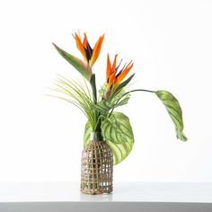 there is a vase with some flowers in it on the table and one has green leaves