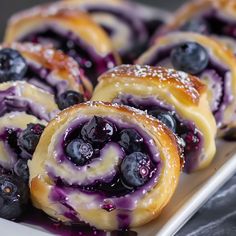 blueberry pastry rolls on a plate with powdered sugar