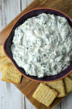 a bowl filled with dip surrounded by crackers