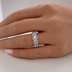 a woman's hand with a diamond ring on top of her finger and the other hand holding it