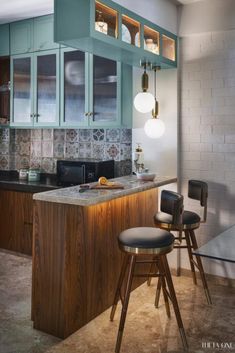 a kitchen with blue cabinets and stools