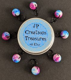 a round metal container with some beads on it and the words j p creations treasures on it