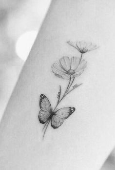 a small butterfly and flower tattoo on the left side of the arm, it is black and white