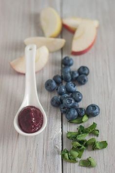 apples, blueberries and spinach puree on a wooden table with text overlay that reads apple, blueberry & spinach puree