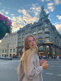 a woman standing in front of a tall building