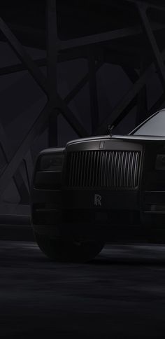 a black rolls royce parked in the dark