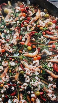 a pan filled with shrimp and vegetables on top of a table