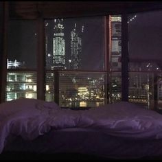 a bedroom with a view of the city at night