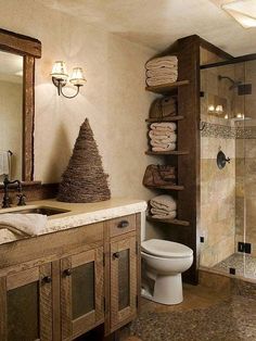 a bathroom with a toilet, sink and shower in it's own area next to a wooden shelf filled with towels