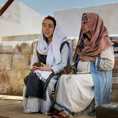 two women sitting on a bench next to each other