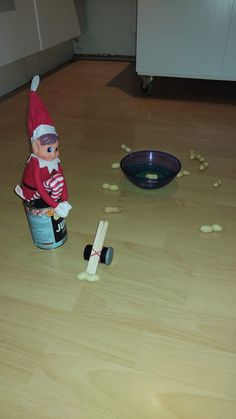 an elf sitting on top of a wooden table next to a bowl