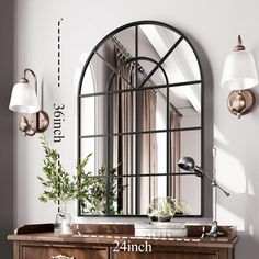 an arched mirror hangs on the wall next to a desk with a potted plant