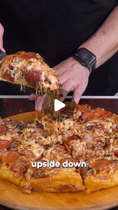 a person is cutting into a pizza on a wooden platter with the words upside down