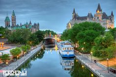 boats are parked along the river in front of some buildings