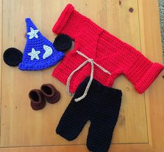 two crocheted items are laying on the floor next to shoes and a hat