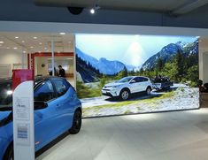 two cars are on display in a showroom