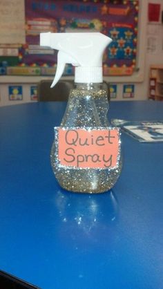 a hand sanitizer sitting on top of a blue table in front of a bulletin board