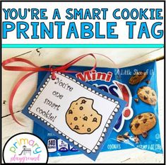 a cookie themed printable tag is on top of a blue bag with red ribbon