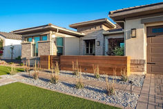 a house with two garages and landscaping in the front yard