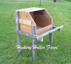 a wooden box sitting on top of a grass covered field