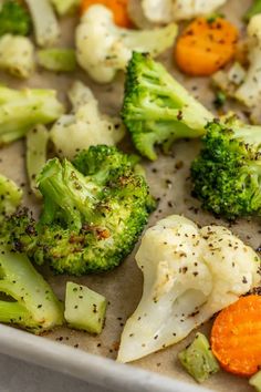 broccoli, cauliflower and carrots in a baking pan with seasoning