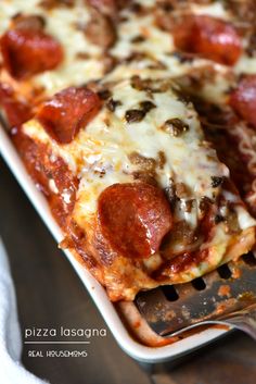 a close up of a pizza on a pan with a spatula in front of it