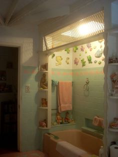 the bathroom is decorated in pastel colors and has teddy bears on the shelves above the bathtub