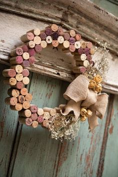 a wreath made out of wine corks hanging on a door