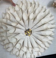 a paper wreath made to look like an origami flower with two hands reaching for it