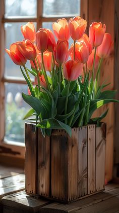 an arrangement of orange tulips in a wooden vase on a window sill