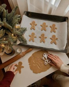 someone is decorating ginger cookies on a tray