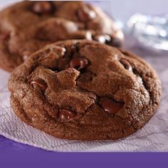 three chocolate chip cookies sitting on top of a paper towel