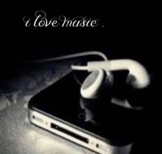 an iphone with earbuds attached to it sitting on a table next to the words i love music