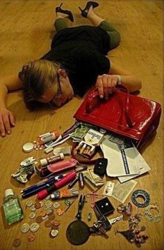 a woman laying on the floor surrounded by various items