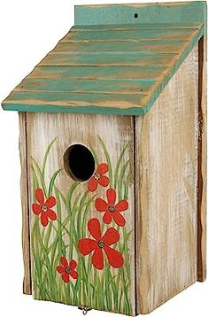 a birdhouse with red flowers painted on it