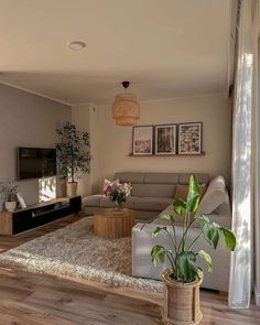 a living room filled with furniture and a flat screen tv on top of a wooden floor