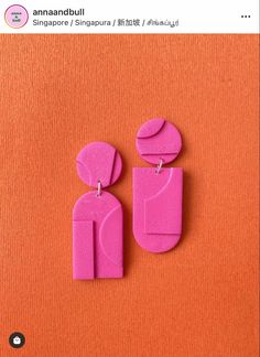 two pink earrings on an orange background with the words anannabull written in chinese