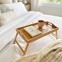 a tray with a book, coffee cup and eyeglasses on top of it