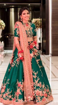 emerald green sabyasachi lengha w floral pattern blush pink details                                                                                                                                                                                 More