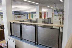 an office building with metal railings and tables in the center, along with bookshelves