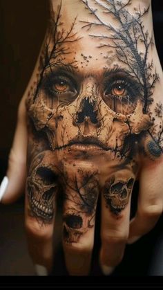 a person's hand with a skull and tree tattoo on it