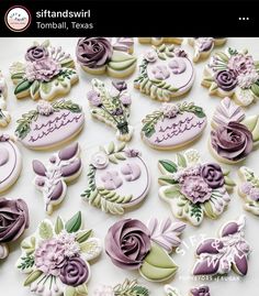 many decorated cookies on a table with flowers and other things in the background that are purple