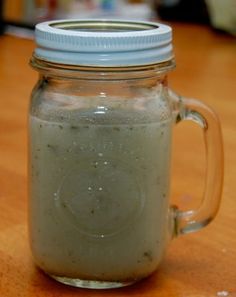 a glass jar filled with liquid sitting on top of a wooden table