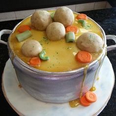 a cake that is sitting on top of a white plate with carrots and dumplings in it