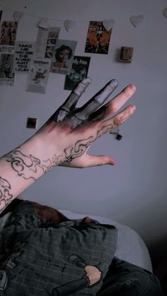 a person with tattoos on their arm and hand