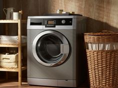 a washer and dryer sitting next to each other in a room with baskets on the floor